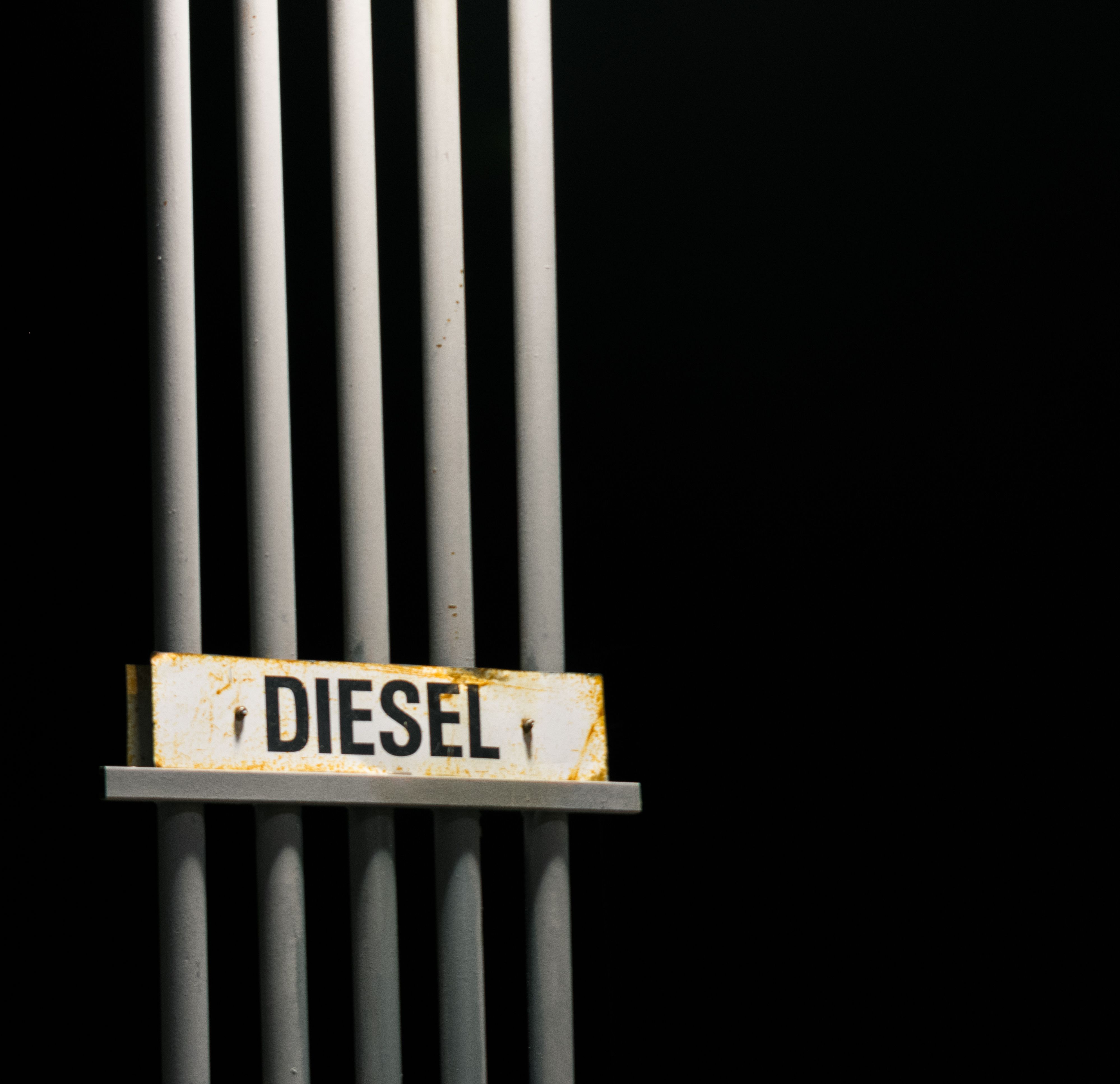 Diesel fuel sign on metal pipes against a dark background at night